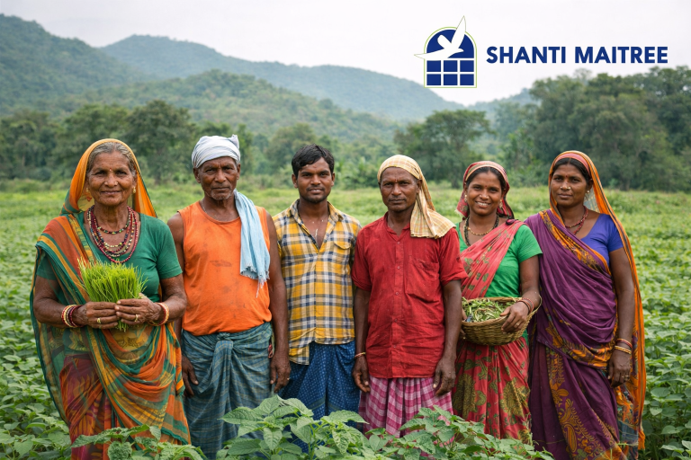 Adivasi community members of Kandhamal district standing in a green farm, representing Shanti Maitree’s rural empowerment initiatives.